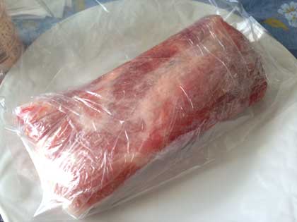 豚肉をサランラップに包み、ビニール袋に入れる